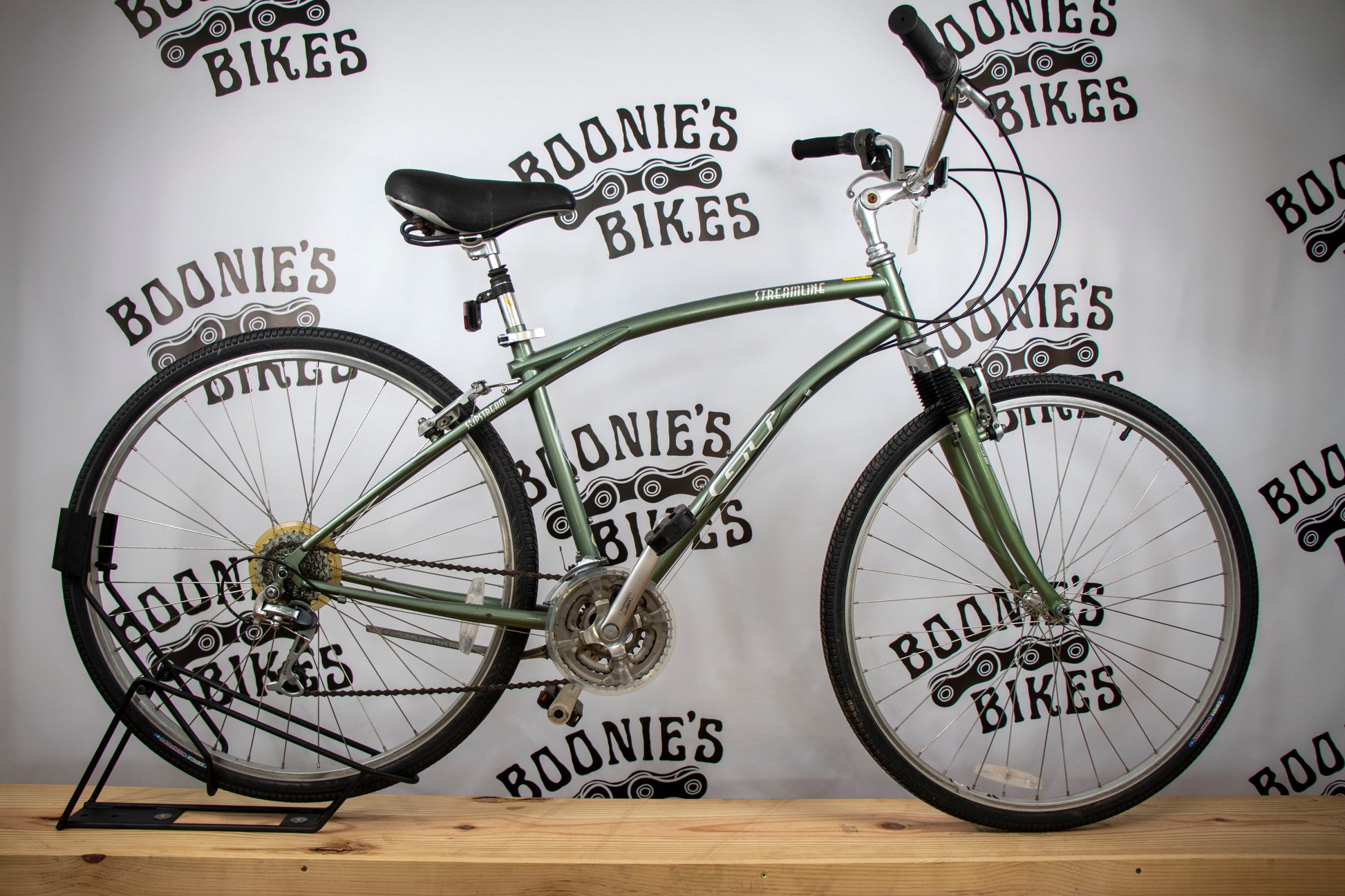 Green bicycle on a stand with 'Boonie's Bikes' branding in the background